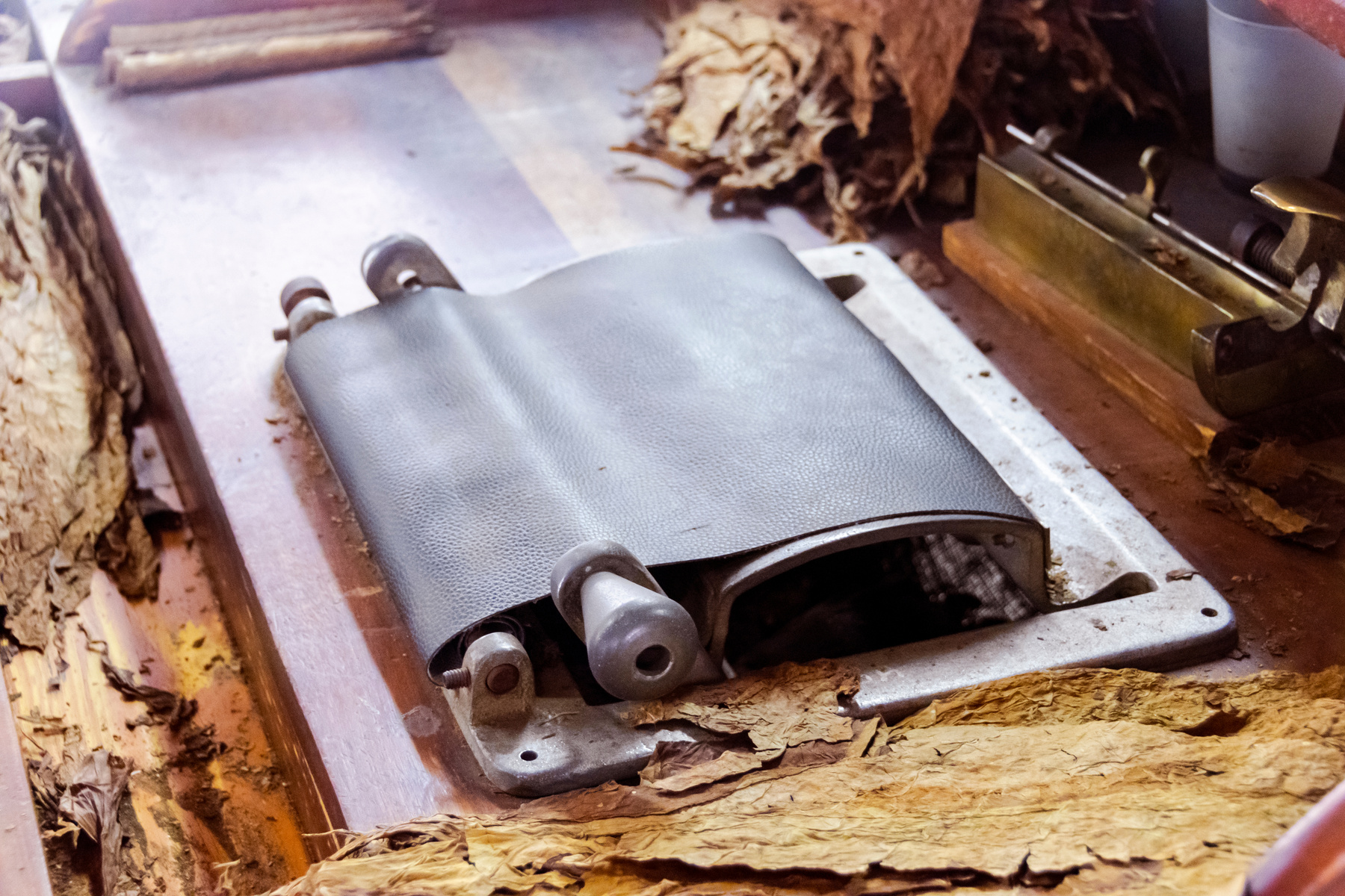 A cigar rolling machine Inside a cigar factory. Traditional manufacture of cigars at the tobacco factory. Making a cigar from tobacco leaves